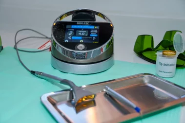 A close-up photograph of a Bio lase Epic dental laser system, safety glasses, and hand piece accessories on a clinical counter.